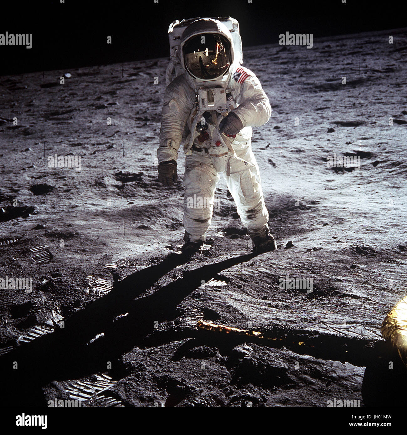 Astronaut Buzz Aldrin, lunar module pilot of the first lunar landing mission, poses for a photograph beside the deployed United States flag during an Apollo 11 Extravehicular Activity (EVA) on the lunar surface. The Lunar Module (LM) is on the left, and the footprints of the astronauts are clearly visible in the soil of the Moon. Astronaut Neil A. Armstrong, commander, took this picture with a 70mm Hasselblad lunar surface camera. While astronauts Armstrong and Aldrin descended in the LM, the 'Eagle', to explore the Sea of Tranquility region of the Moon, astronaut Michael Collins, command mod. Stock Photo