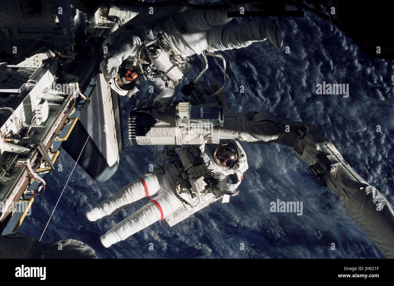 Astronauts Linda M. Godwin (red stripes) and Daniel M. Tani, both STS-108 mission specialists, are pictured near the end of the Space Shuttle Endeavour's remote manipulator system (RMS) robotic arm during the four-hour, 12-minute session of extravehicular activity (EVA). Stock Photo