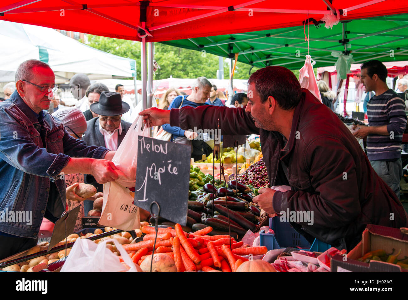 Trader selling vegetables to a customer at Wazemmes Market (Marché de Wazemmes), Lille, France Stock Photo