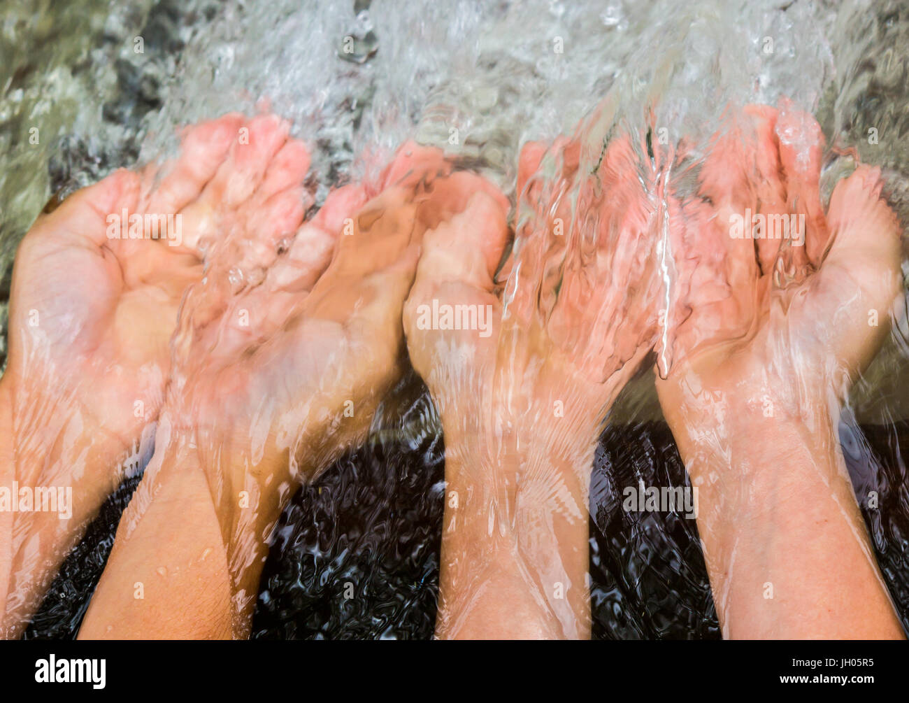Pair of Hands on Water Stream Stock Photo