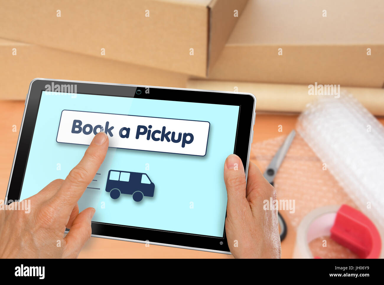 Booking a courier online with a collection of packaging materials and boxes Stock Photo