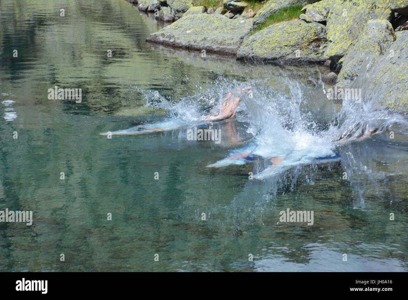 Jumping in to a mountain lake at 2230m above sea level Stock Photo