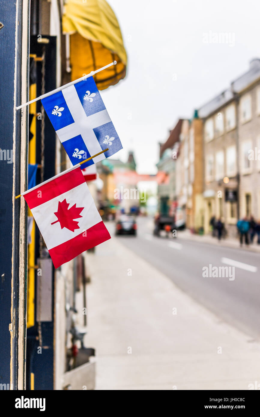 Quebec City, Canada - May 29, 2017: Closeup of two small Canadian and Quebec flags hanging on restaurant on Saint Louis street in old town road Stock Photo