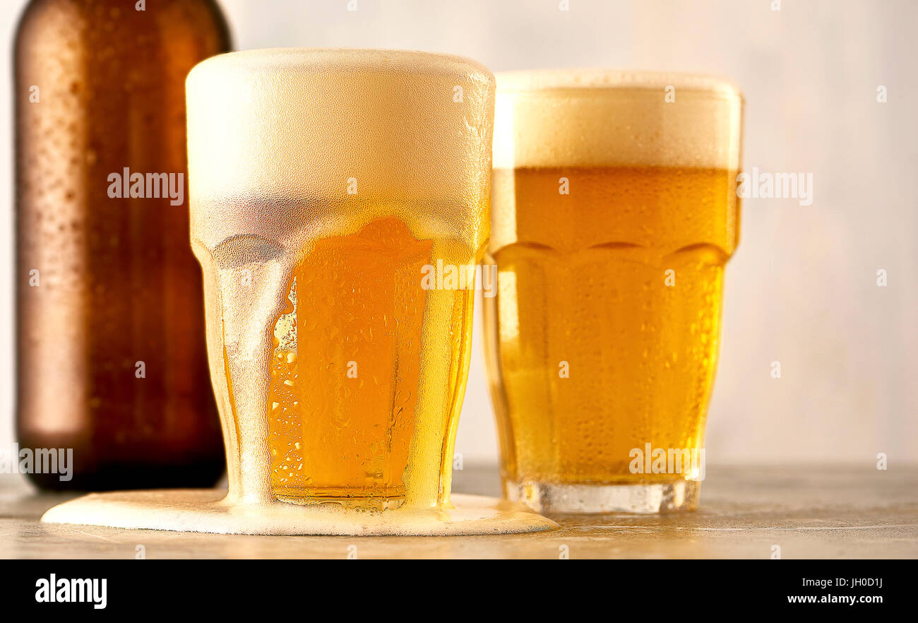 Glass or craft beer overflowing with foam Stock Photo