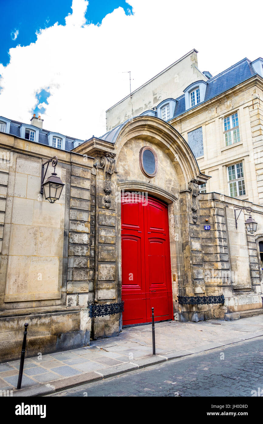 A beautiful bright red door on an old building in Paris, France Stock Photo