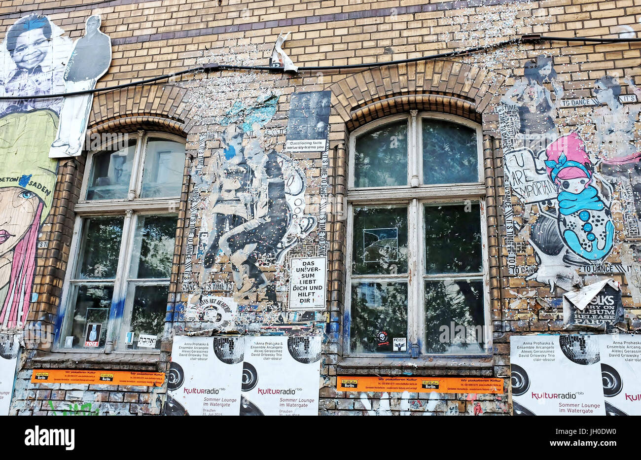 Graffiti art displayed on a brick building in the Kreuzberg neighborhood of Berlin, Germany channels social commentary via street art. Stock Photo