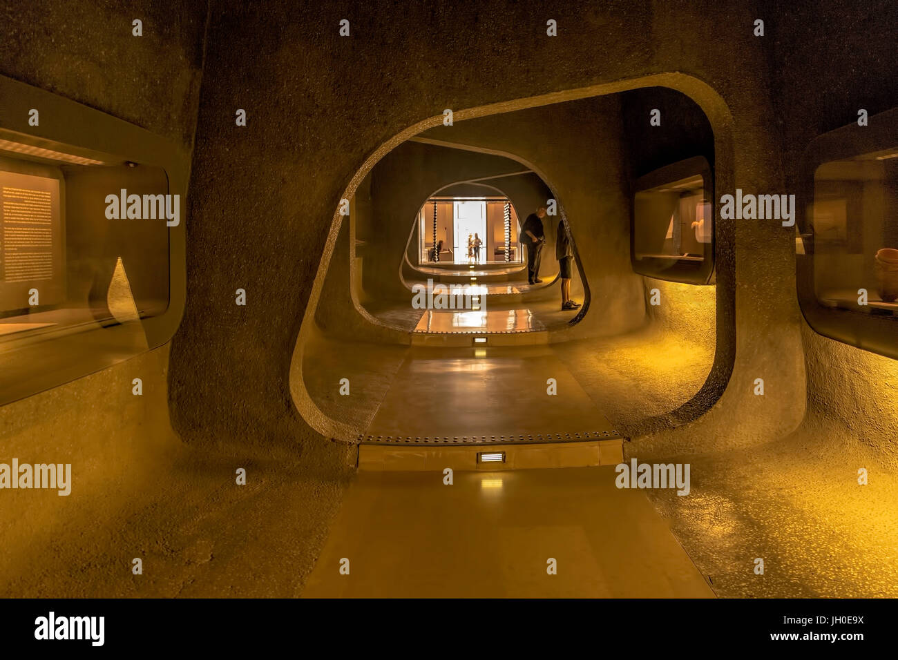 View into a dark cave-like passage with exhibits towards the entrance area of the Israel Museum in Jerusalem, Israel, famous for the Dead Sea Scrolls. Stock Photo