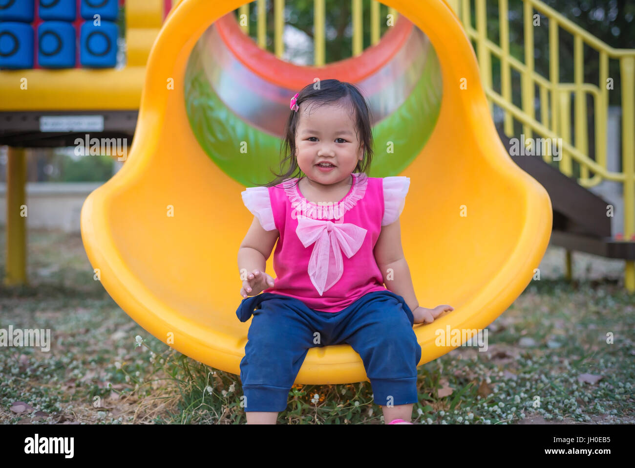 Toddler girl playing on a slide at children playground Stock Photo - Alamy