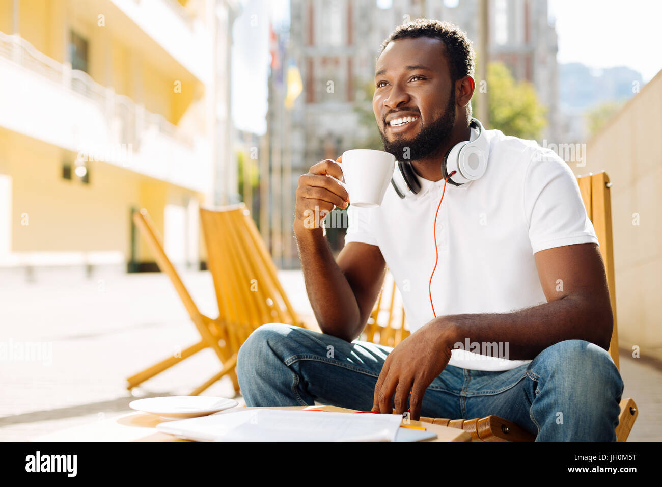 Confident optimistic man enjoying coffee on a terrace Stock Photo