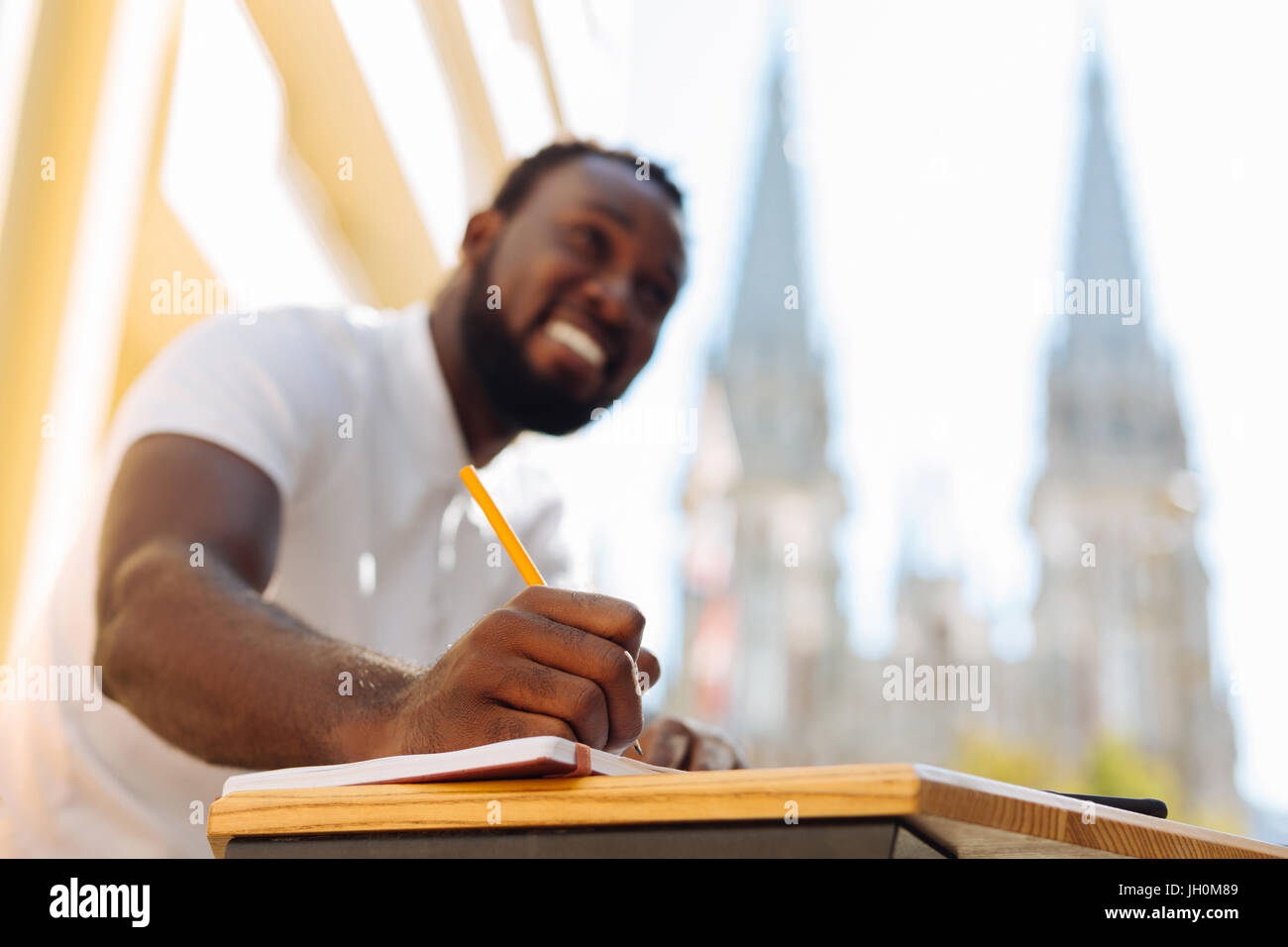 Industrious optimistic guy writing down something Stock Photo