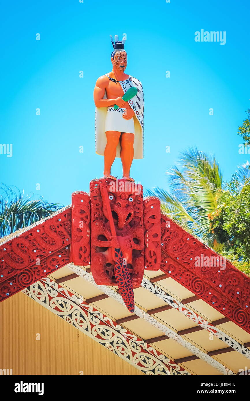 Honolulu, Hawaii - May 27, 2016: A carved wooden statue of a Maori man on top of the meeting house on the Marae at the Aotearoa Village inside the Pol Stock Photo