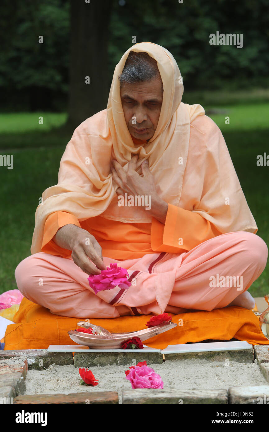 Swami Veetamohanda performing a puja in the garden of the Ramakrishna vedantic center. Gretz. France. Stock Photo