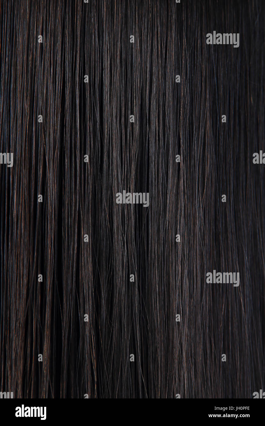 Long straight black hair. Dark woman hair texture. Black female hair background. Stock Photo