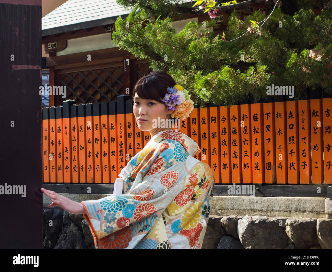 Young Japanese woman posing in street wearing traditional Kimono. Stock Photo