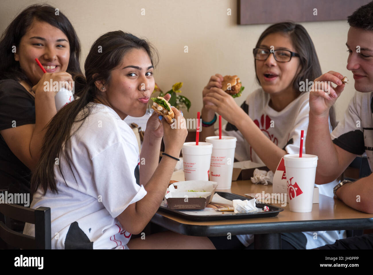 Chick-fil-A fans enjoying a meal with friends on Cow Appreciation Day at Chick-fil-A, America's top-rated fast food restaurant. Stock Photo