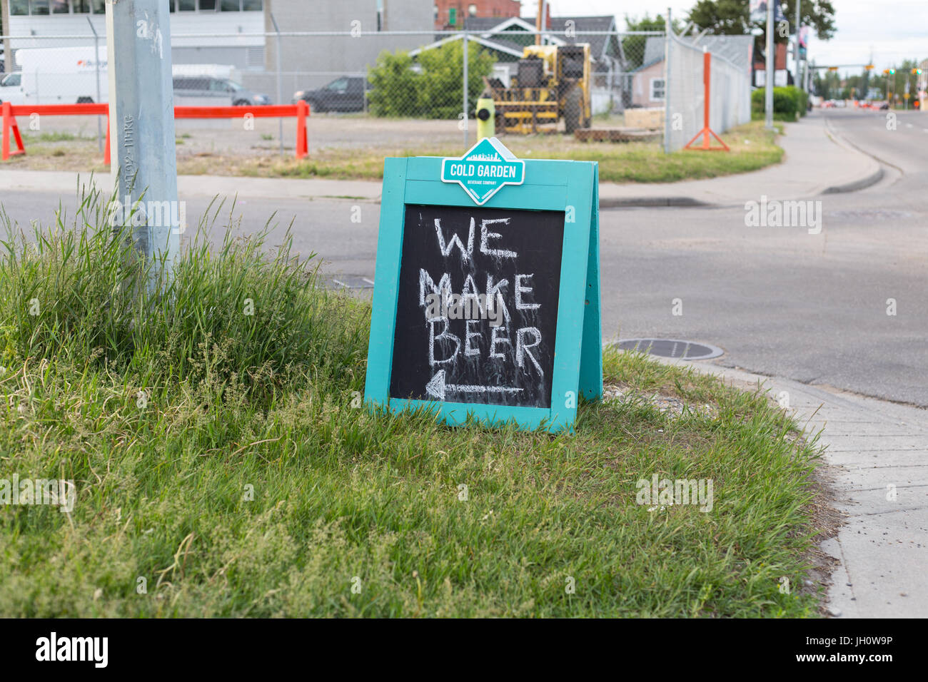 A chalkboard saying 'We make beer' standing on the side of the road near Cold Garden Beverage Company in Inglewood, Calgary, Alberta, Canada Stock Photo