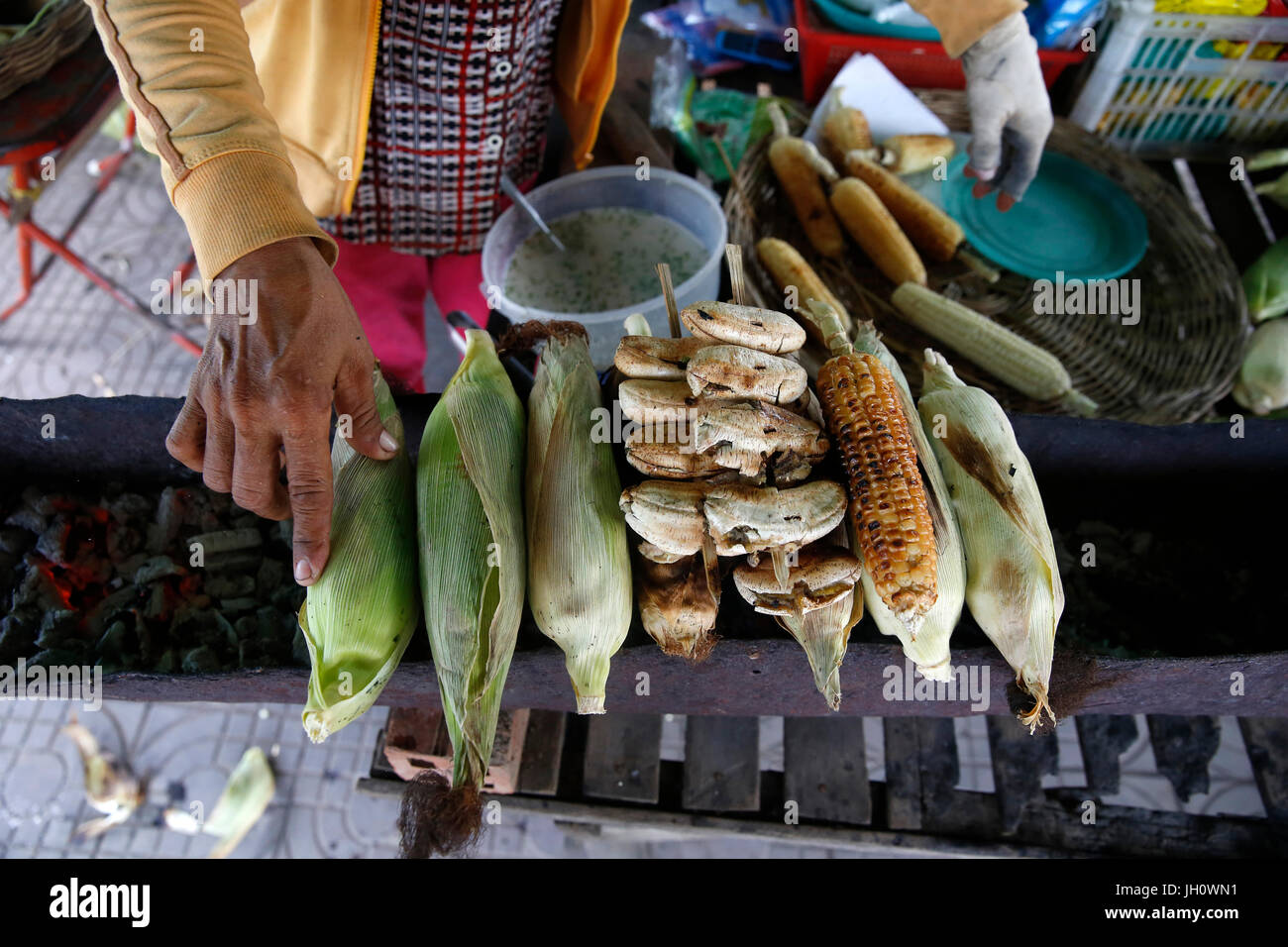 Tab Sreyneang runs a banana & corn roasting stand and a bicycle repair shop financed by a 1,4 million riel 1st loan from Chamroeun microfinance. Cambo Stock Photo
