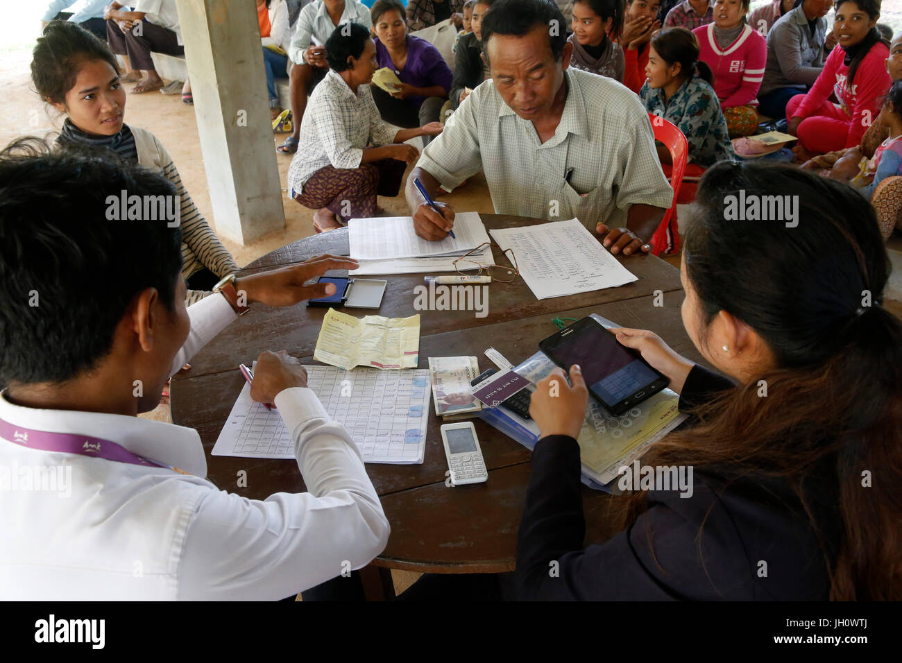 AMK microfinance and CARD (Council for agricultural and rural development) disbursing funds for beneficiaries of a Unicef program. Cambodia. Stock Photo