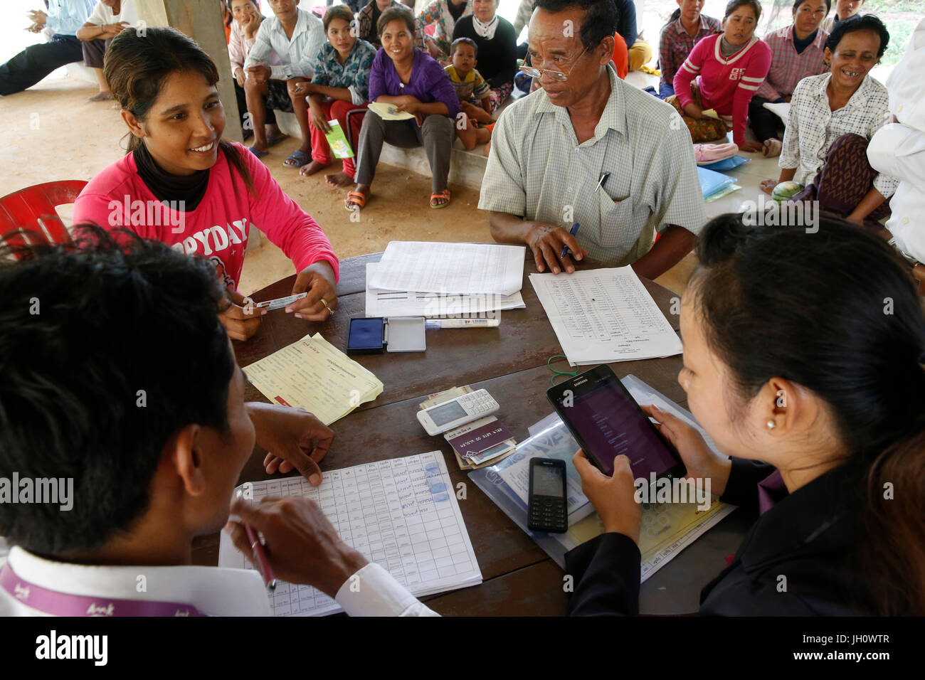 AMK microfinance and CARD (Council for agricultural and rural development) disbursing funds for beneficiaries of a Unicef program. Cambodia. Stock Photo