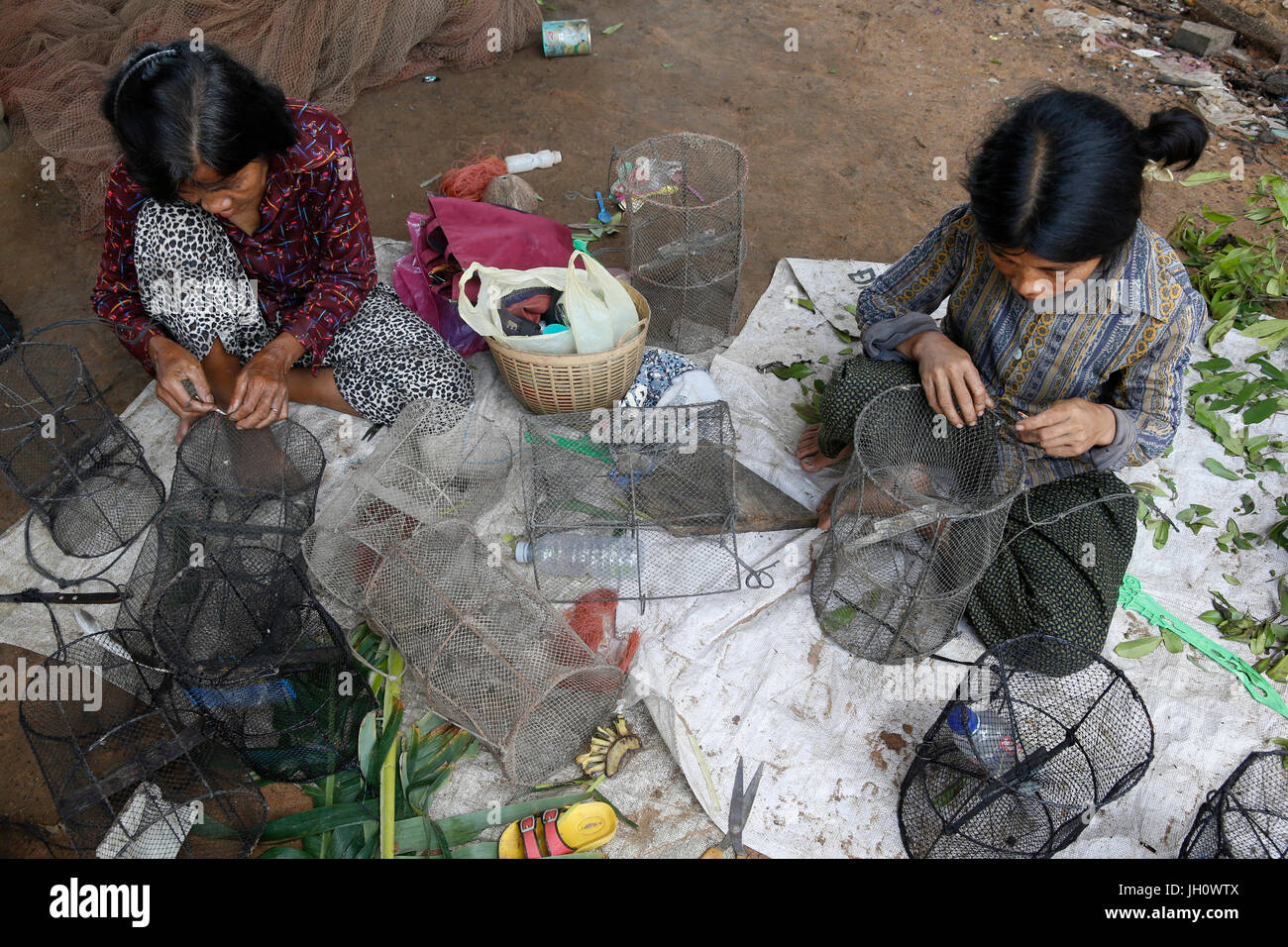 AMK microfinance clients repairing fishing equipment. Cambodia. Stock Photo