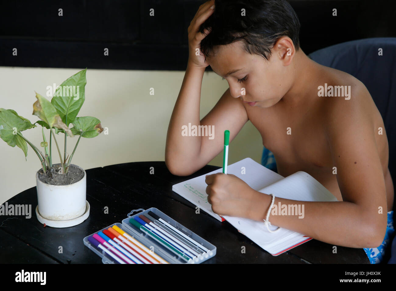10-year-old European boy writing a vacation diary. Cambodia. Stock Photo