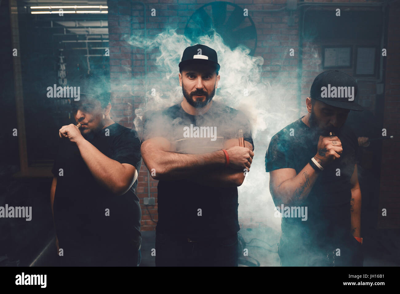 Three men vaping in an authentic room with brick walls. Vaping an