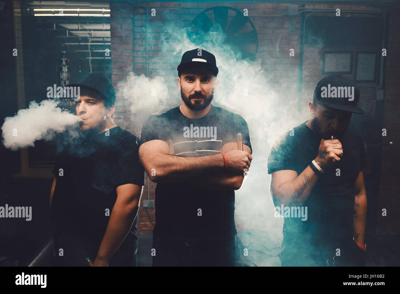 Three men vaping in an authentic room with brick walls. Vaping an