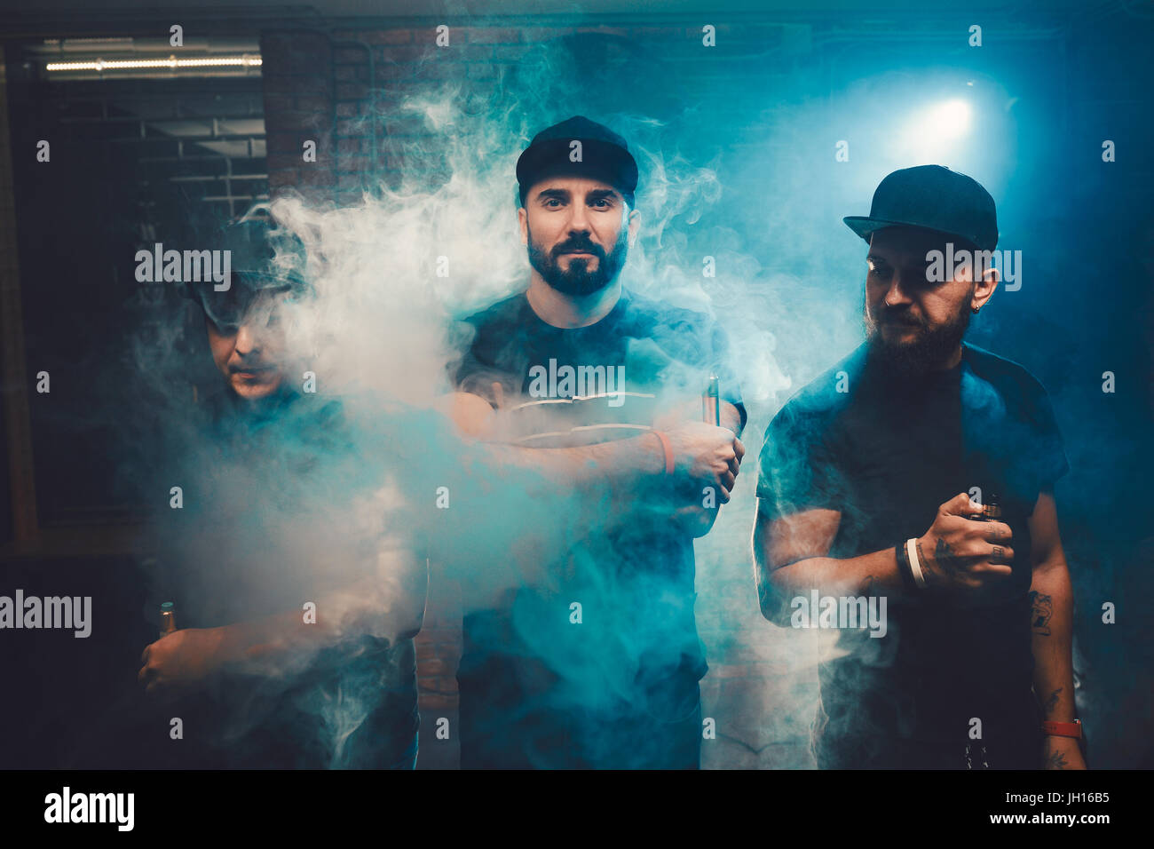 Three men vaping in an authentic room with brick walls. Vaping an