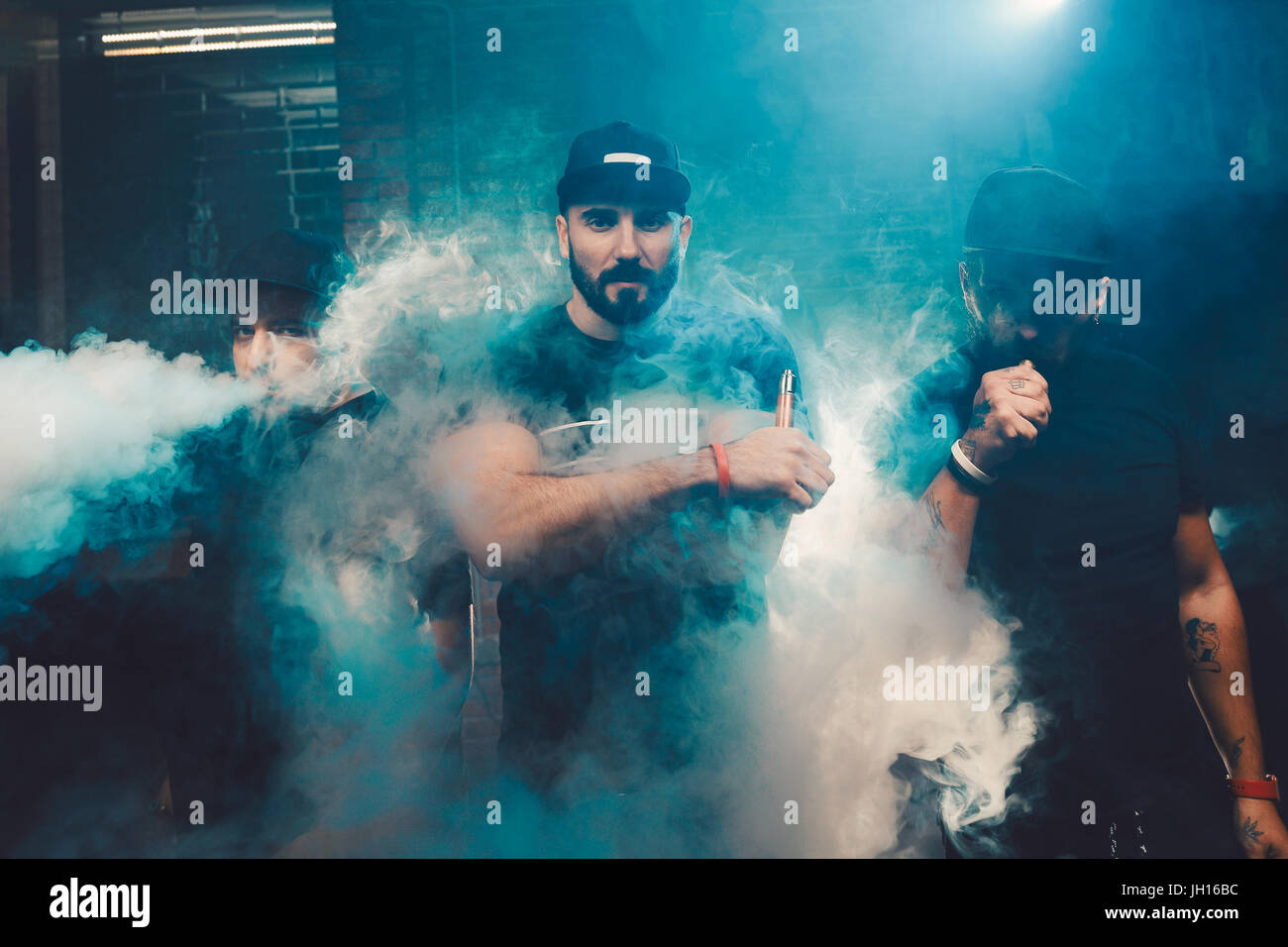 Three men vaping in an authentic room with brick walls. Vaping an