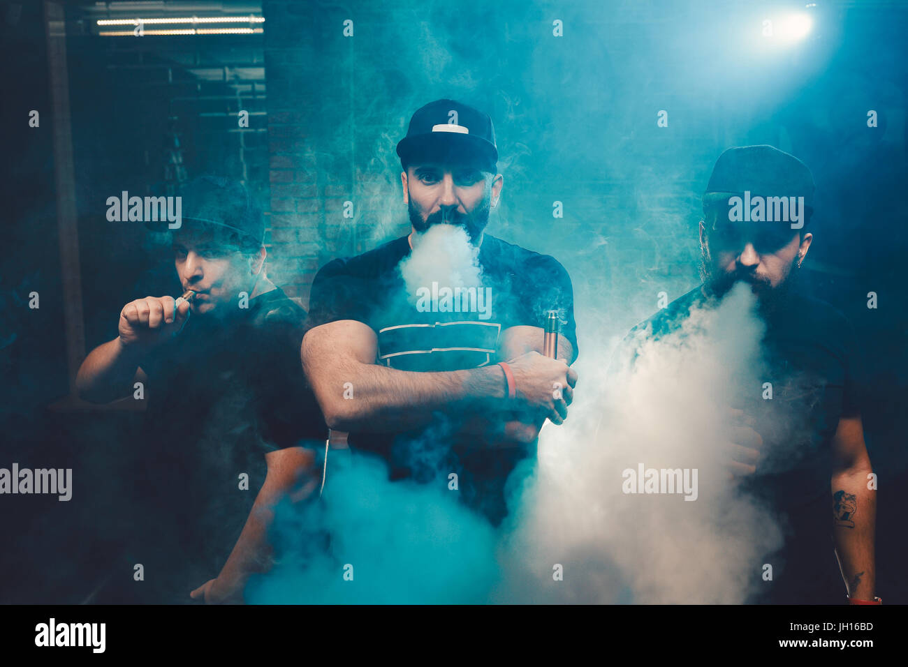 Three men vaping in an authentic room with brick walls. Vaping an