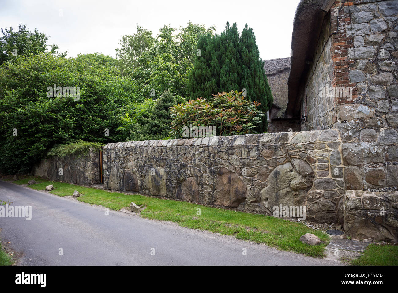 Garden wall constructed from huge local sarsen stones in East Kennet village, Wiltshire, UK Stock Photo