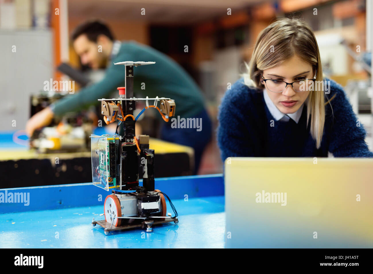Young engineer testing his robot in workshop Stock Photo