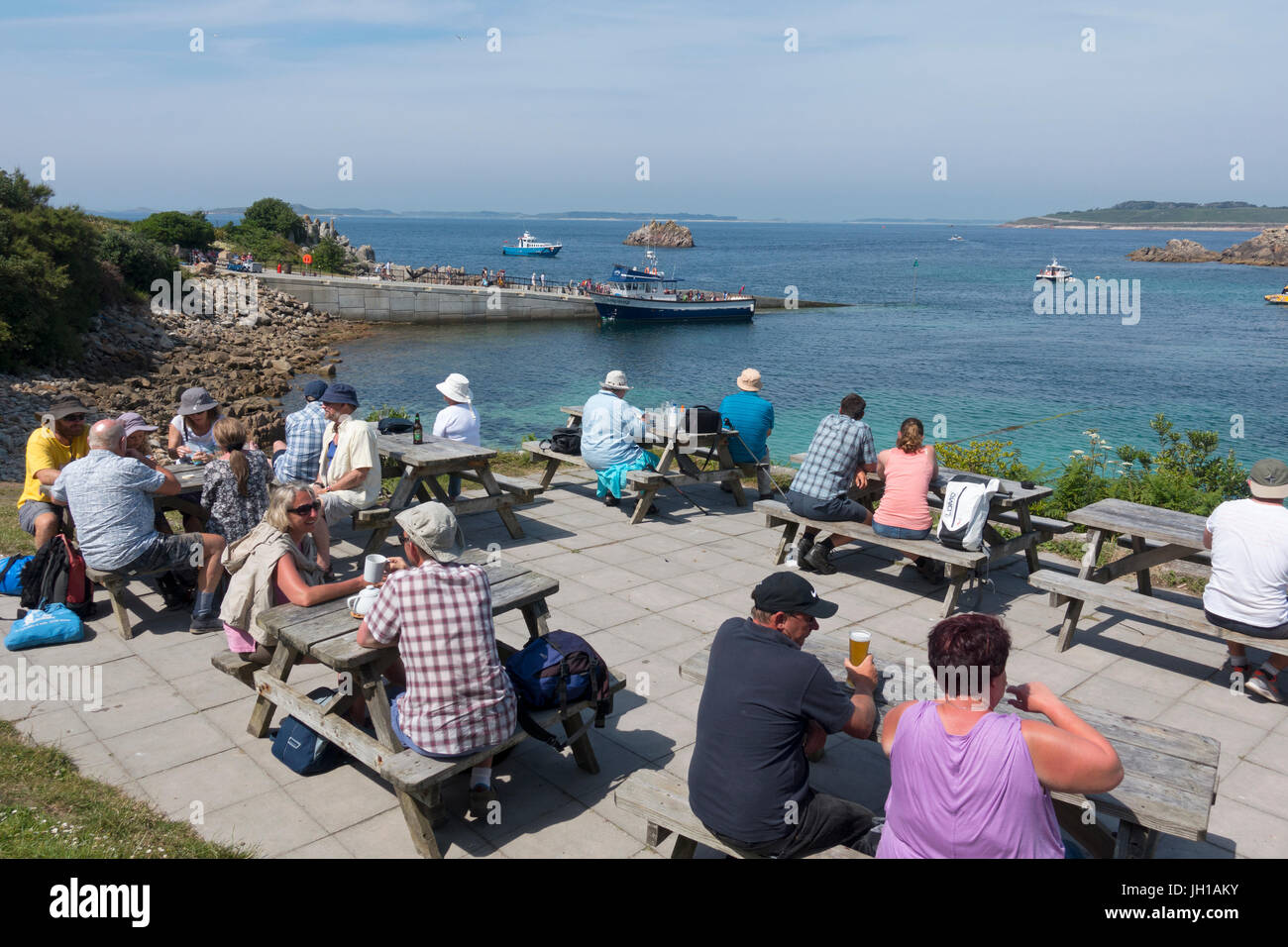 People eating and drinking outside the Turks Head pub in St. Agnes, Isles of Scilly, Cornwall England UK. Stock Photo