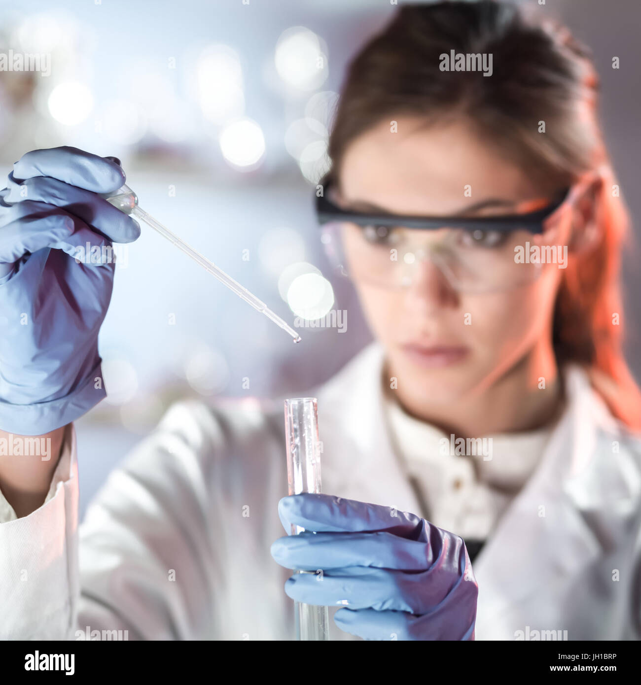 Young scientist pipetting in life science laboratory. Stock Photo