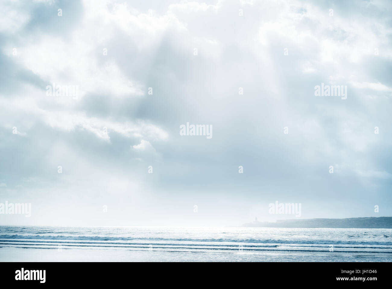 Beach and sea with cloudy sky and sunbeams. High key, soft effect image. Stock Photo