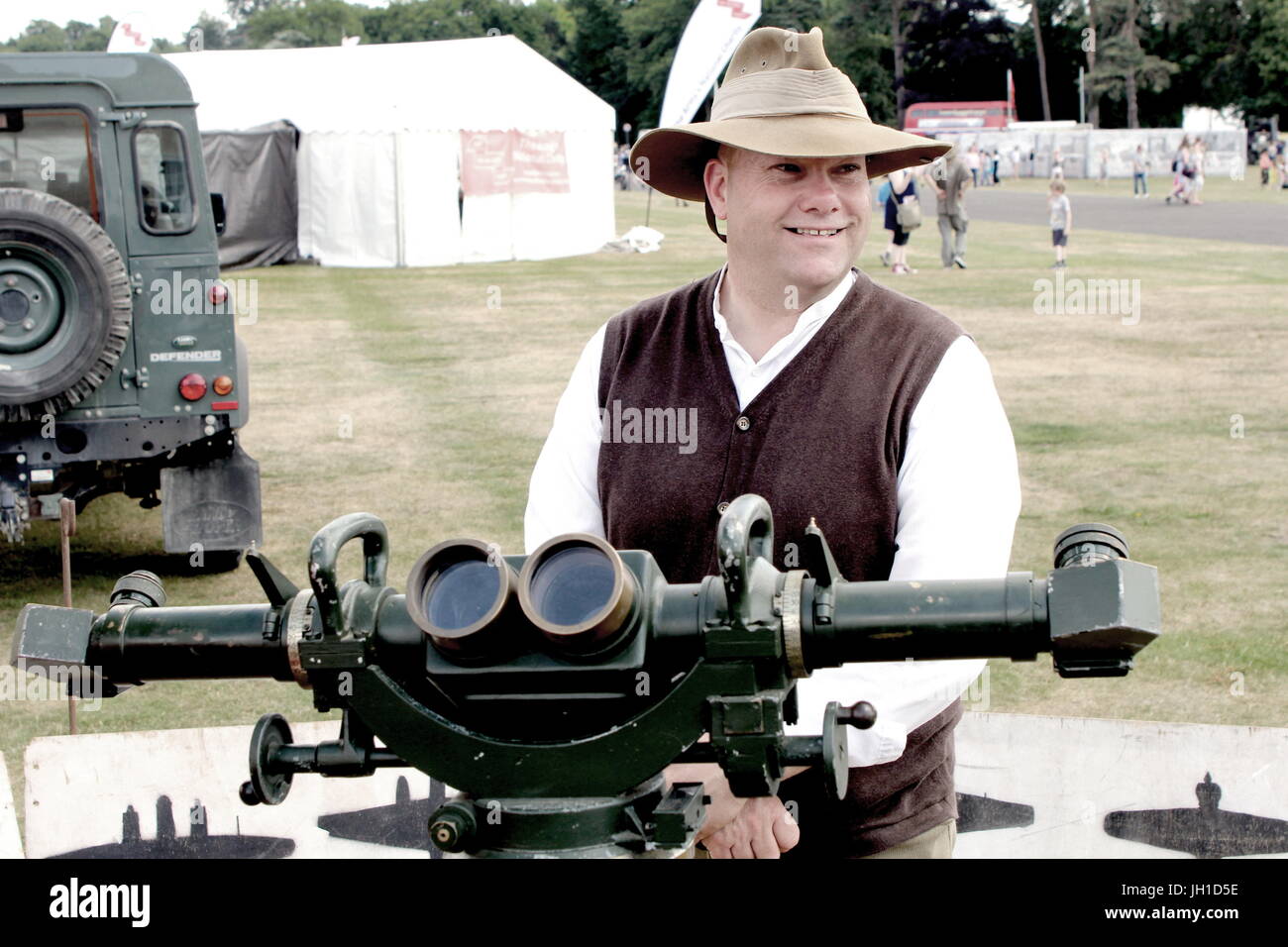 Vintage toned shot of an enthusiast demonstrating a WW2 rangefinder at