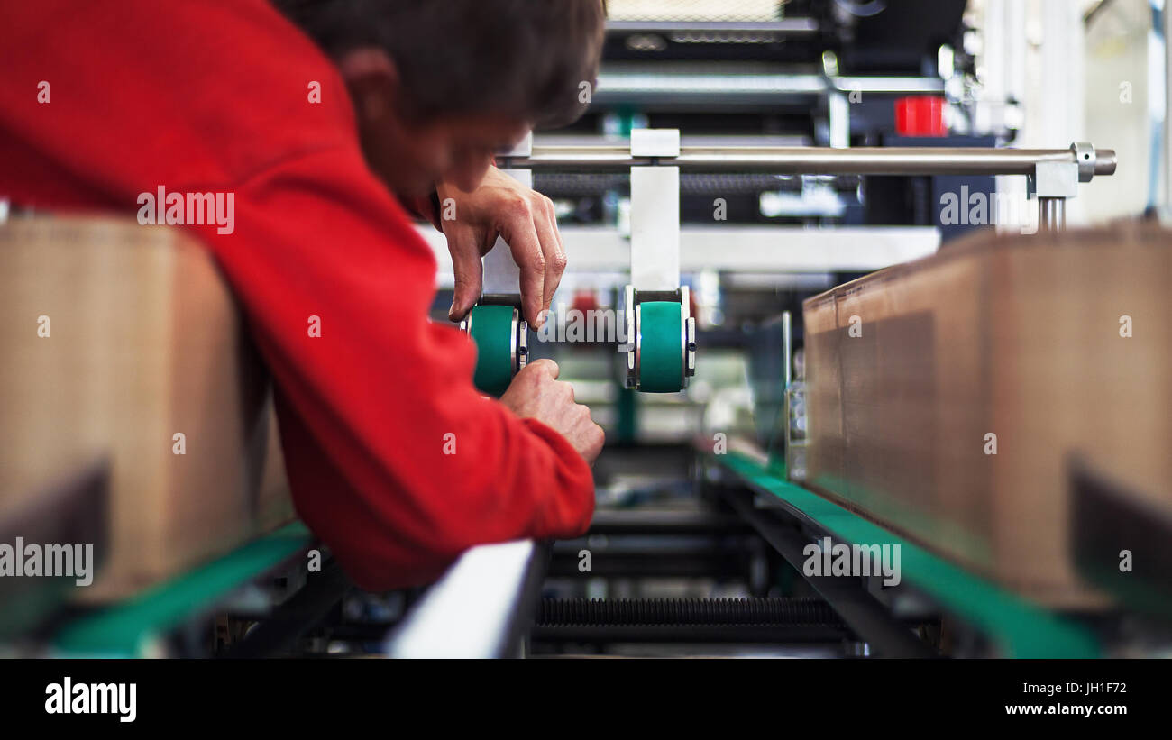Man on industrial machine, production line details. Stock Photo