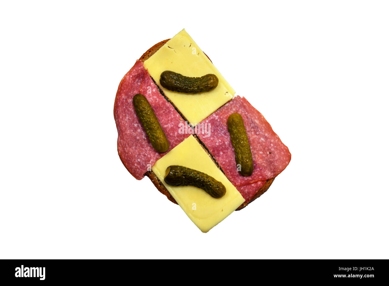 Bread slice with sausage and cheese and a small cucumber on white background. Stock Photo