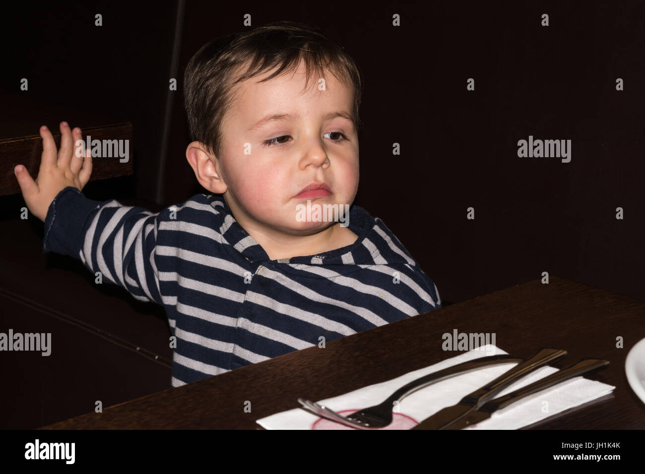 Man and boy sitting at a dining table hires stock photography and
