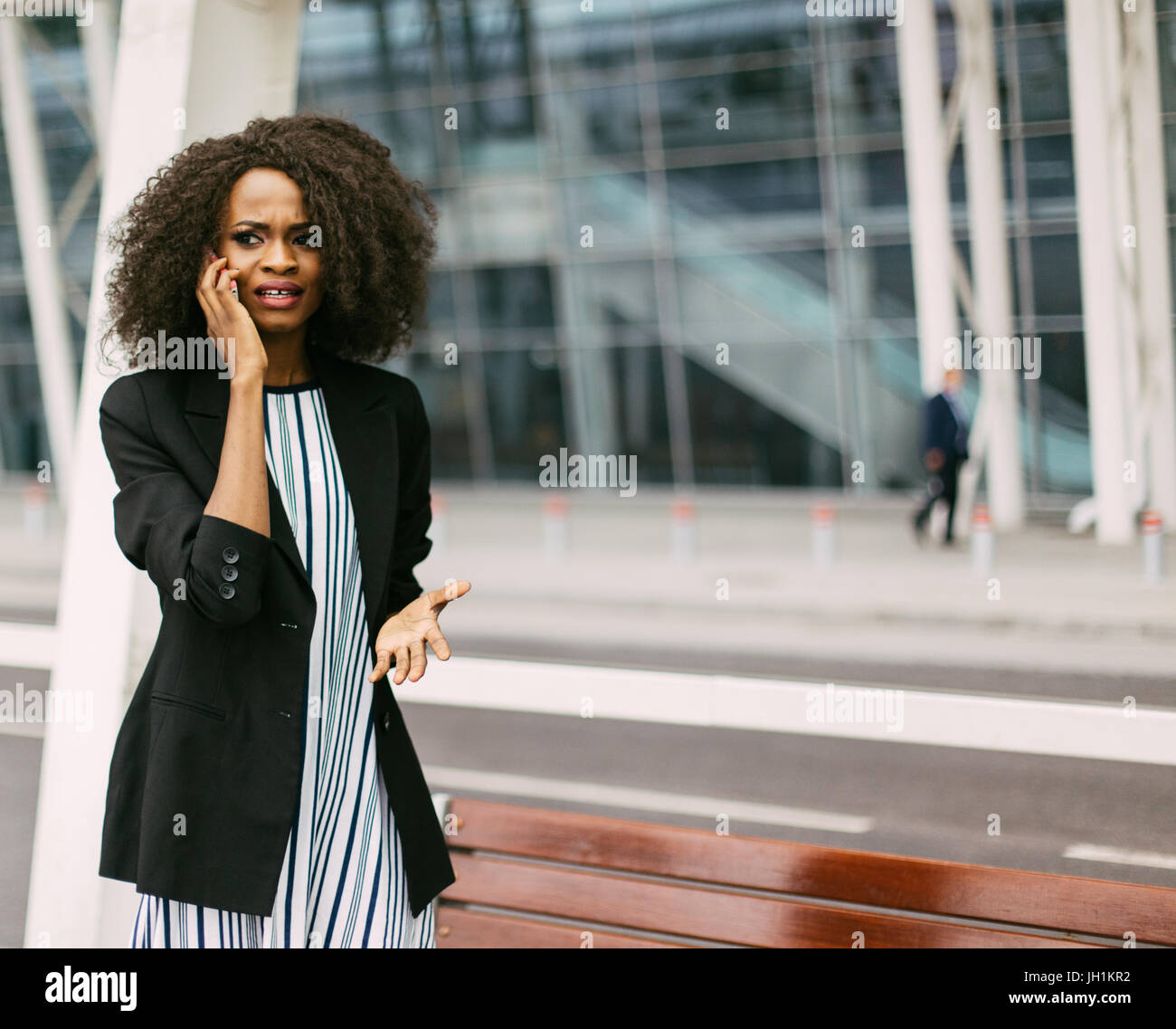 Beautiful afro-american girl is upset while talking via the cellphone. Stock Photo