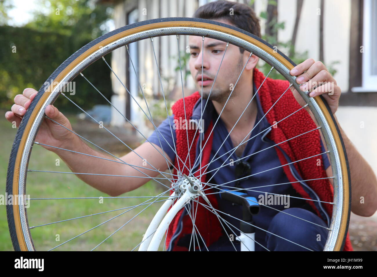Young man inflating a bicycle tyre. France. Stock Photo