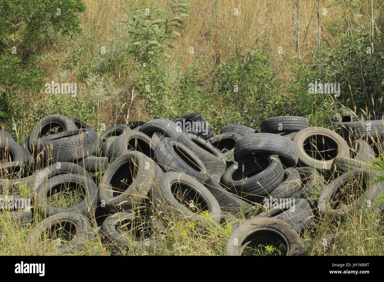 Other peoples rubbish, old dumped tyres or tires. Stock Photo