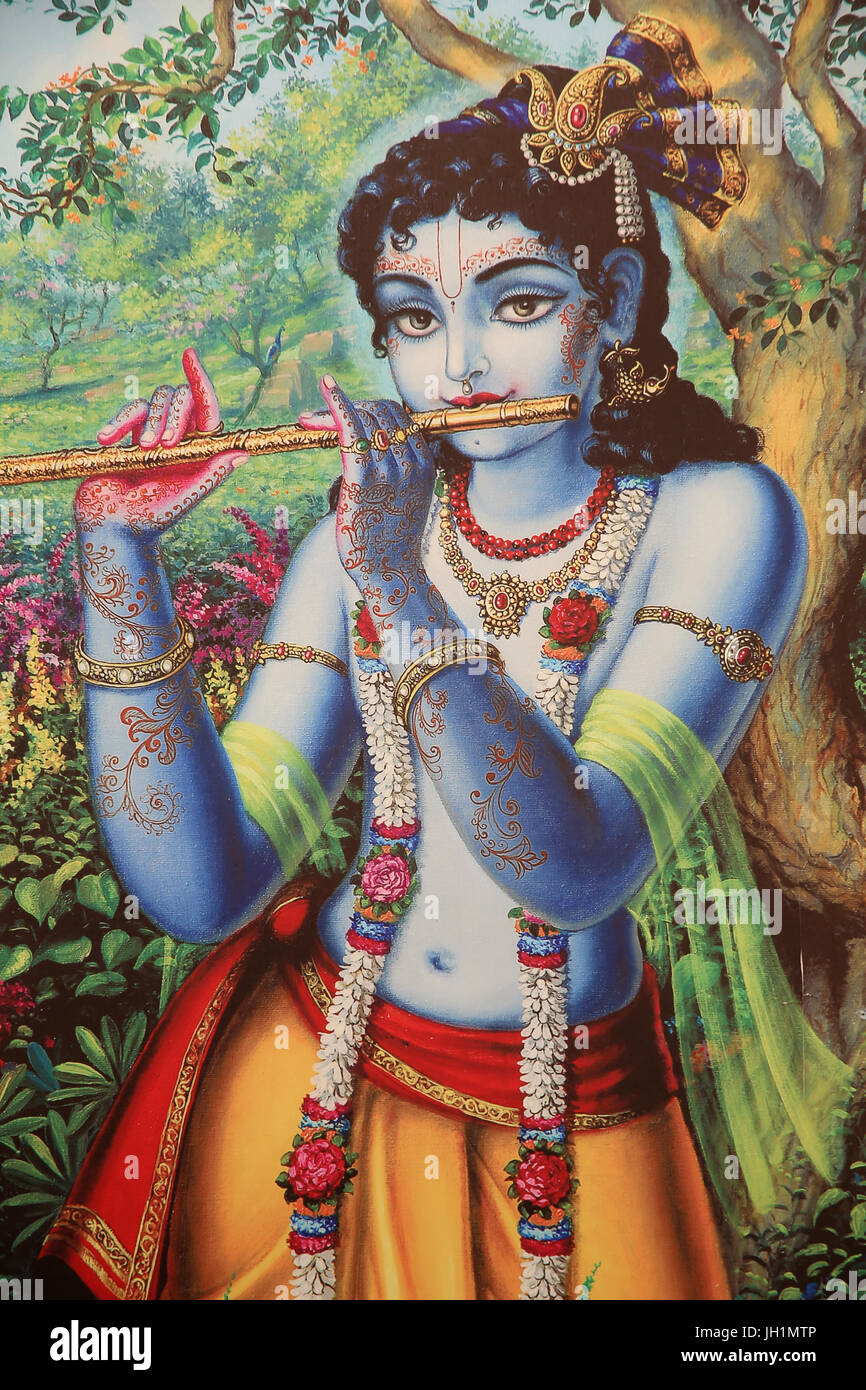 Painting depicting Hindu god Krishna playing a flute outdoors. India. Stock Photo