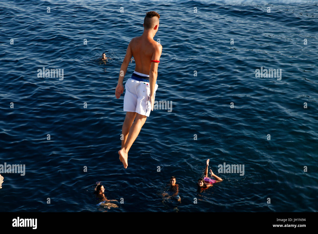 Young man jumping into the Med. Italy. Stock Photo