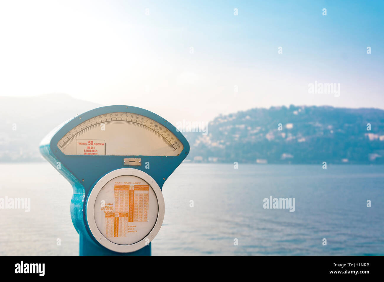 https://c8.alamy.com/comp/JH1NRB/large-analog-scale-with-the-lake-of-como-in-the-background-JH1NRB.jpg