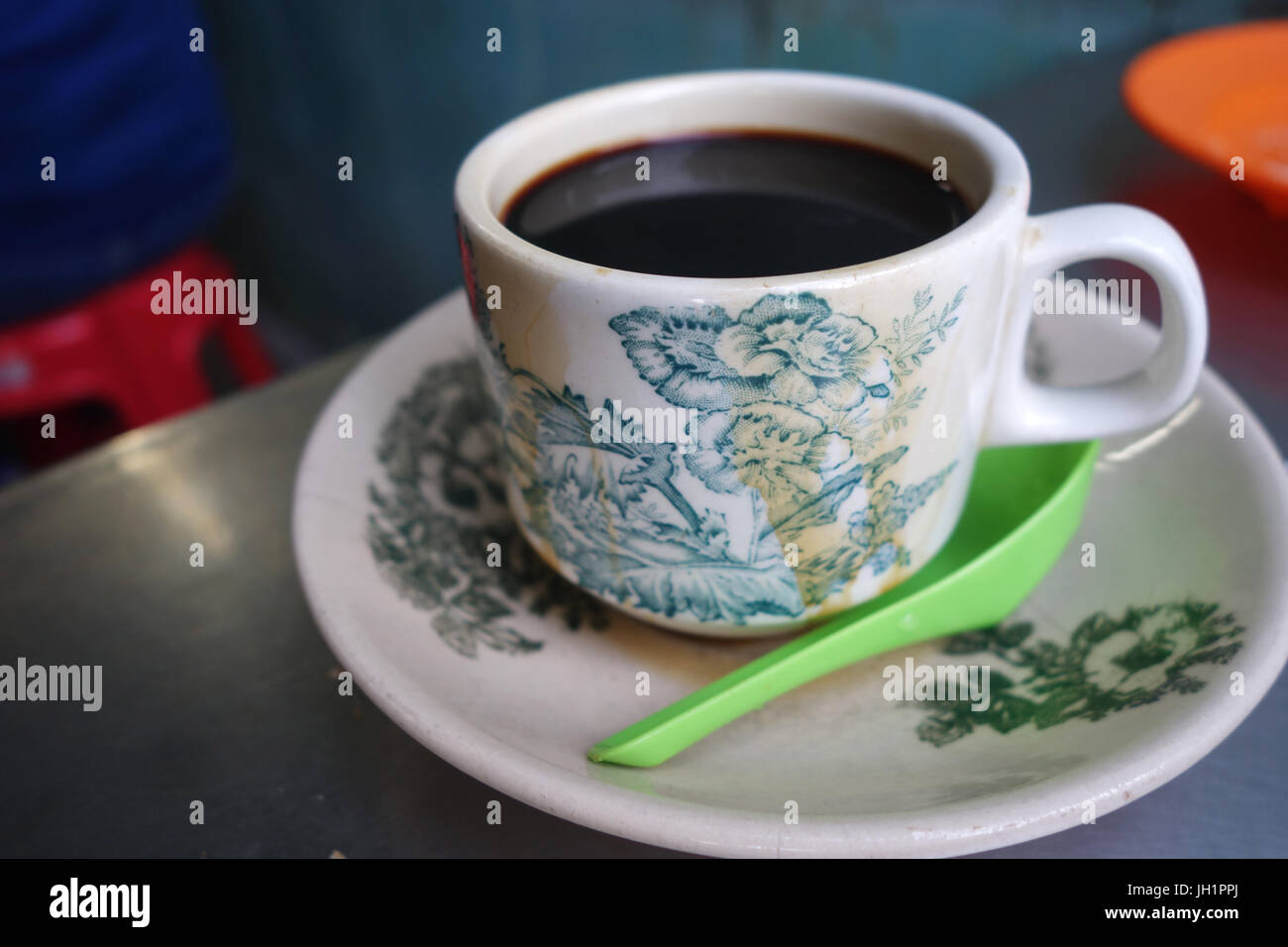 Steaming traditional oriental Chinese kopitiam style dark coffee in vintage mug and saucer Stock Photo