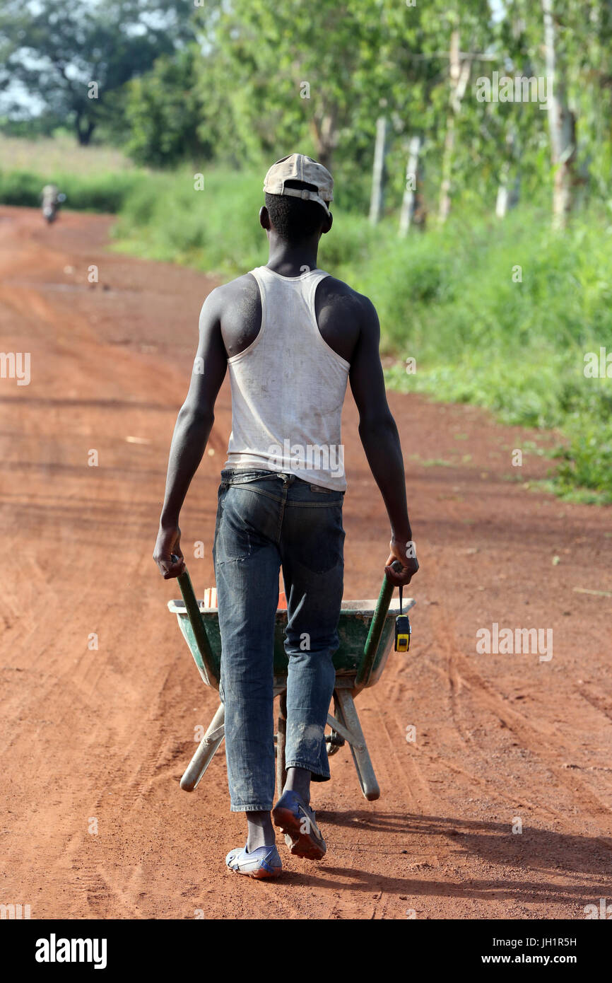 Worker pushing wheelbarrow.  Togo. Stock Photo