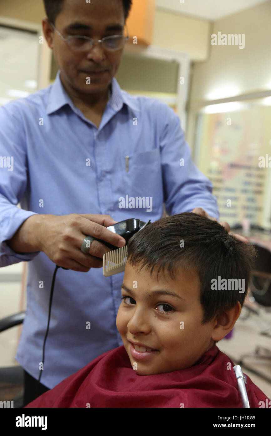 10-year-old boy getting a haircut in Bangkok. Thailand. Stock Photo