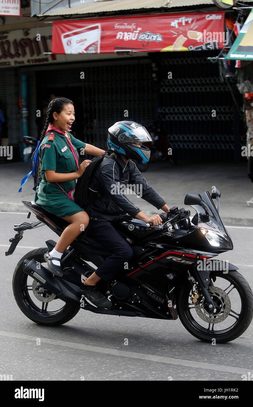 Schoolgirl riding a scooter with her father. Thailand. Stock Photo