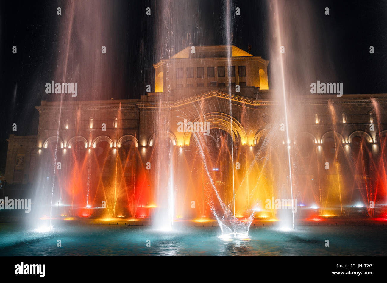 The colored singing musical dancing fountains against the building of the National Gallery and History Museum of Armenia Stock Photo